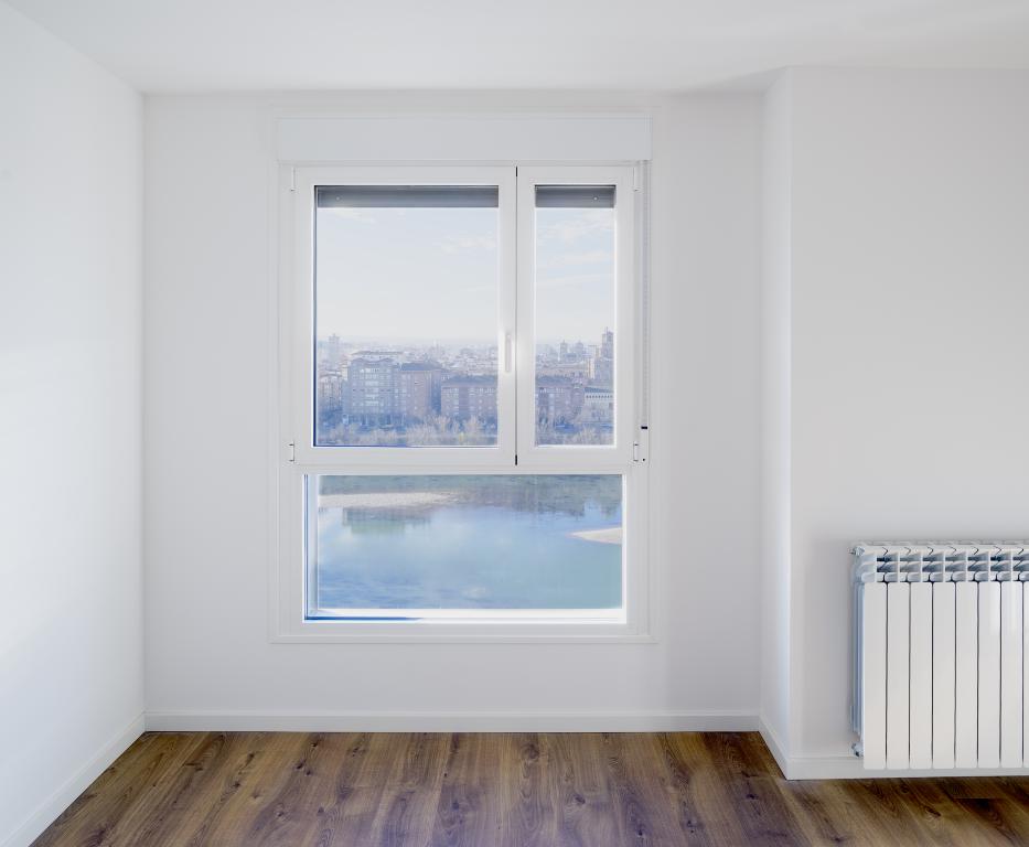 An empty room with a radiator and a CITY view.
