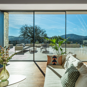 A living room with a view of the mountains, featuring the Cor vision Slimline Aluminium door.